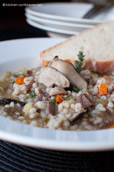 A bowl of beef, mushroom, and barley soup.