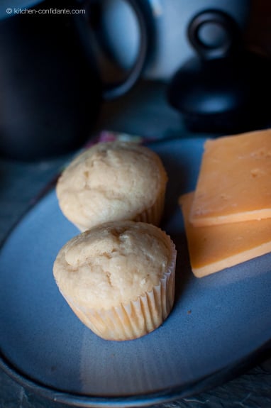 Leftover muffins on a blue plate - ready to be eaten with the two slices of sharp cheddar cheese.