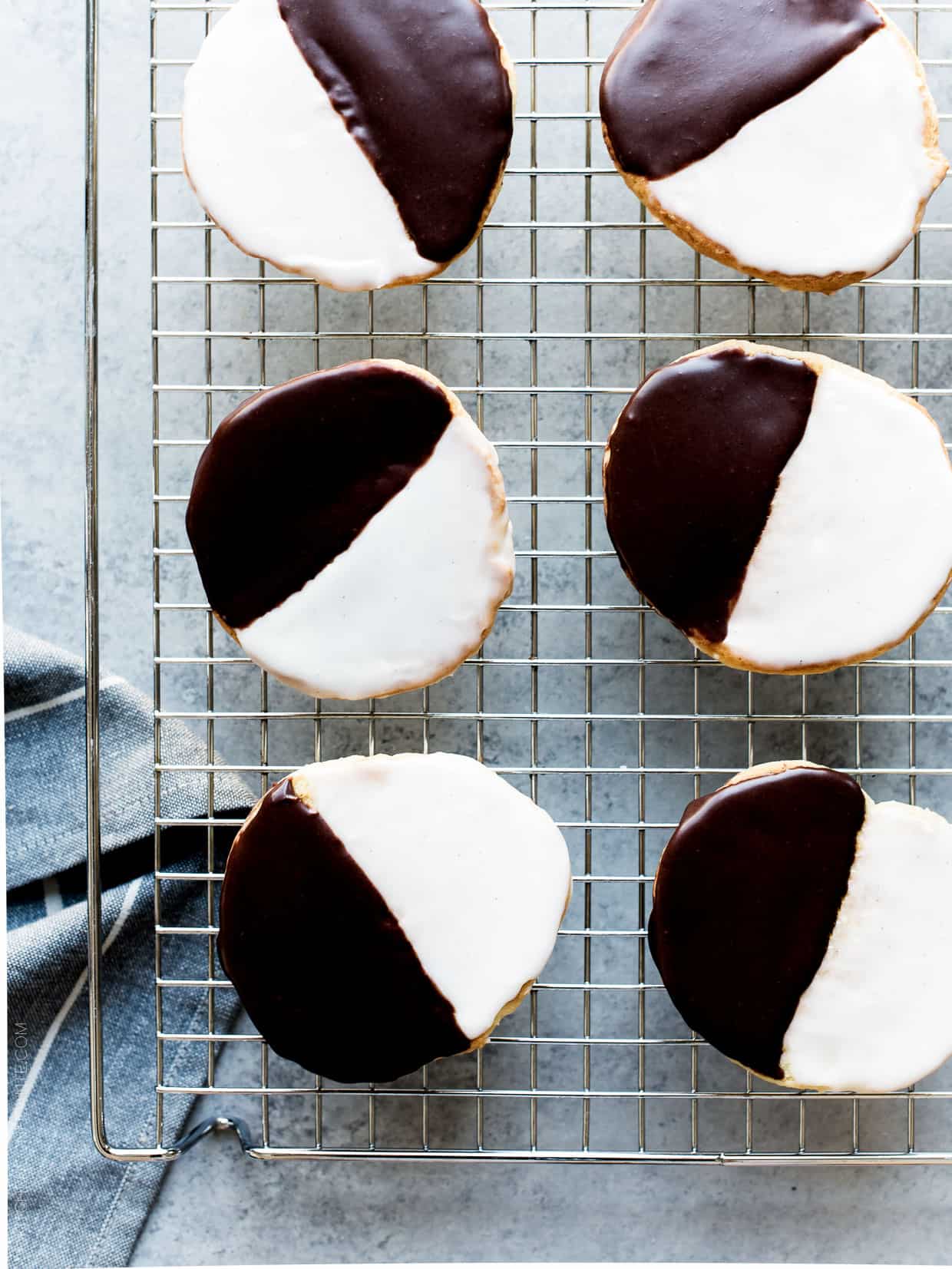 Black and White Cookies - a New York deli classic. Frosted with vanilla and chocolate icing, these cake-like cookies deliver the best of both worlds.