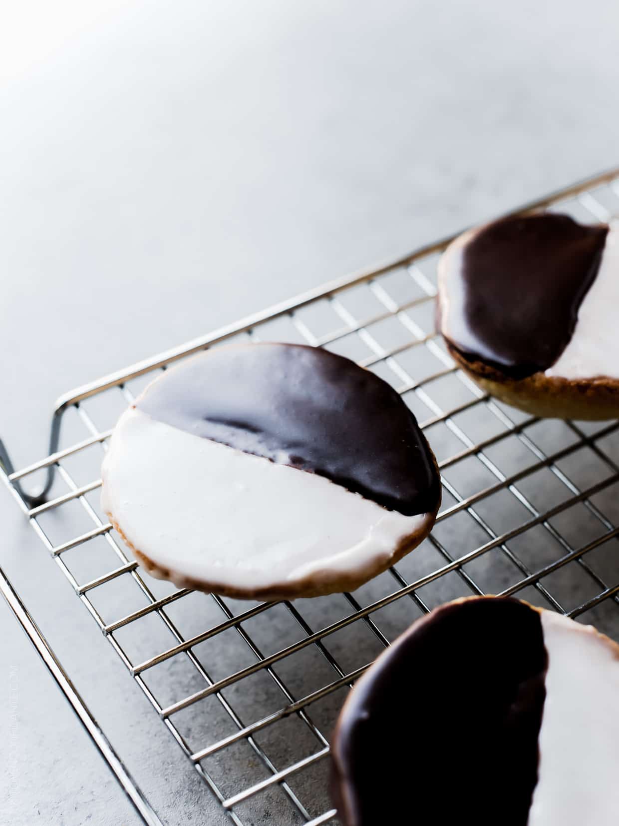 Black and White Cookies - a New York deli classic. Frosted with vanilla and chocolate icing, these cake-like cookies deliver the best of both worlds.