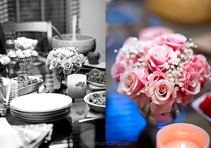 Setting up my "pink party" for breast cancer awareness. Image of a dinner table full of food, decorated with pink roses and candles.