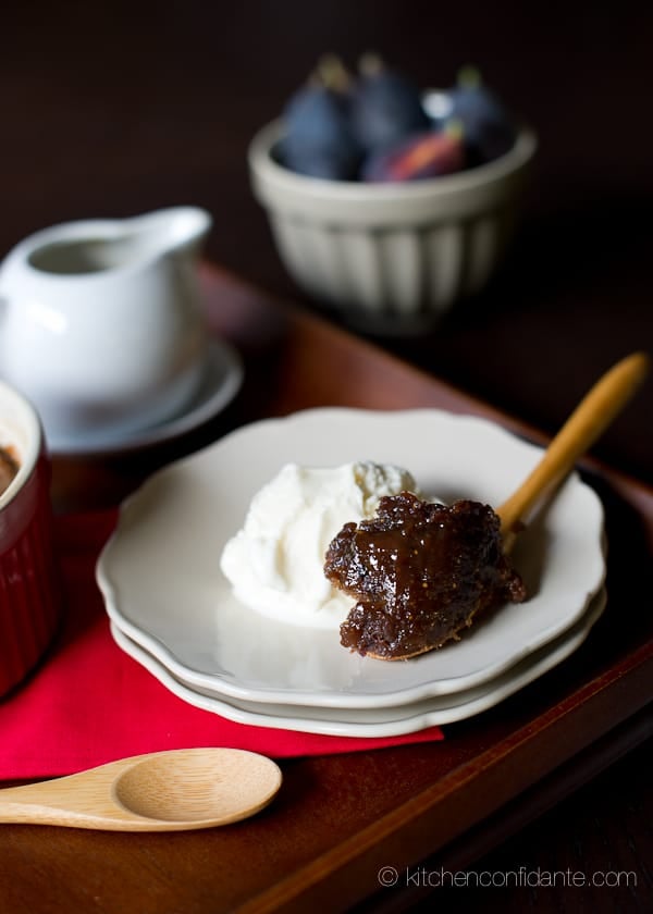 A scoop of vanilla icecream sits on a saucer beside a spoonful of Sticky Toffee Pudding Cake.