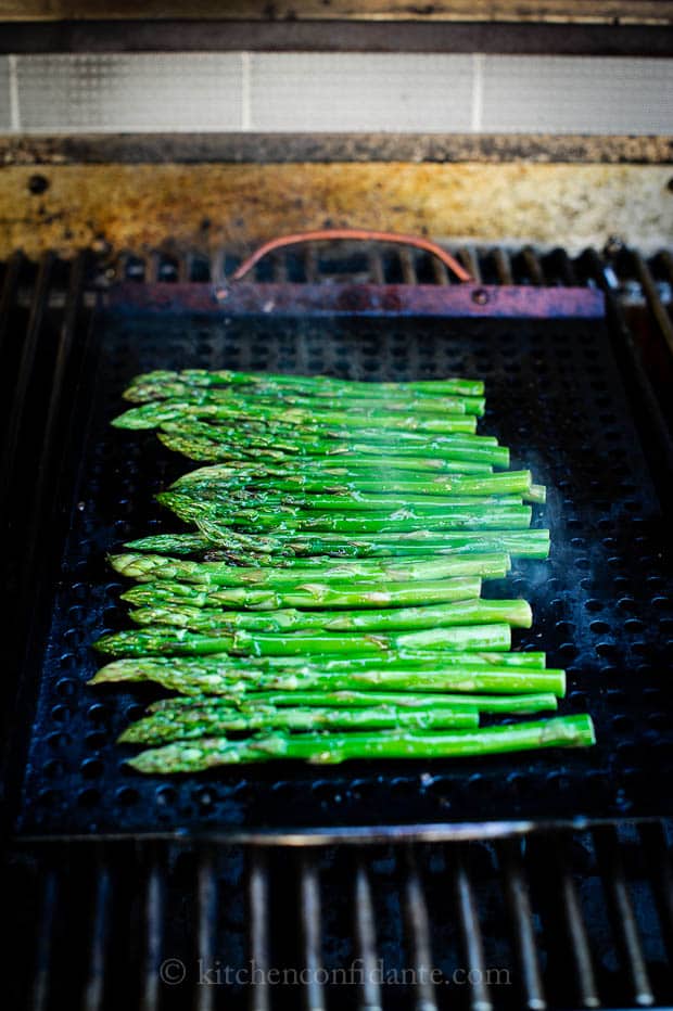 Asparagus laid out on a grill to cook.