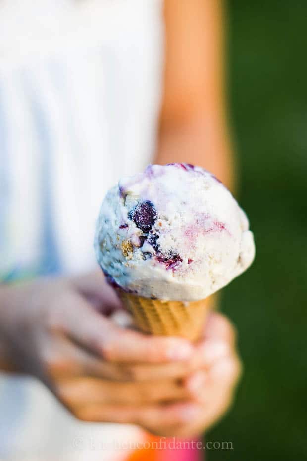 Blueberry crisp ice cream in a cone.