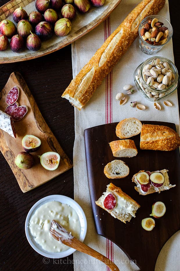 Goat Cheese Crostini with Figs and Honey, with all of the ingredients laid out on a charcuterie board.