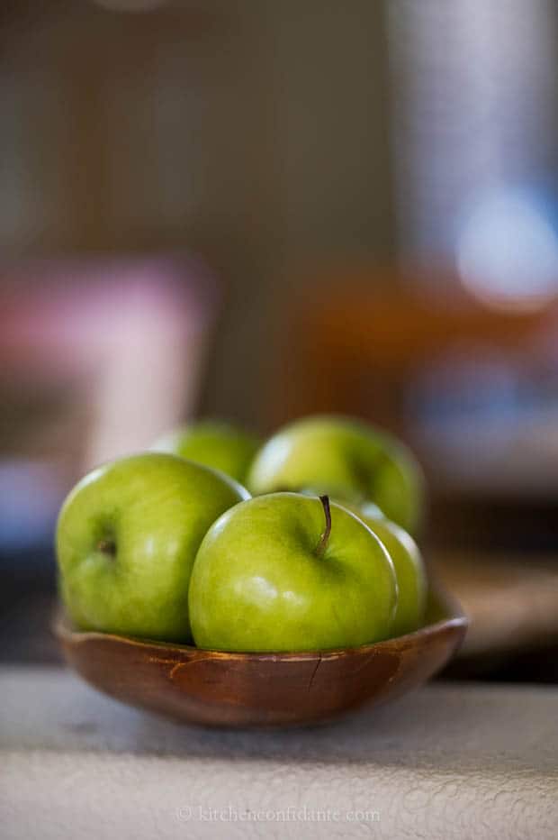 A bowl of green granny smith apples, ready to make apple dumplings with.