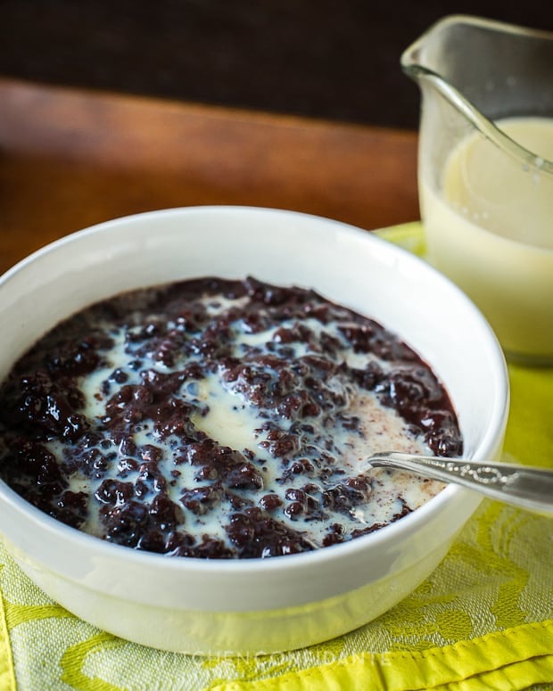 A bowl of Champorado (Filipino Chocolate Rice Pudding) freshly topped with condensed milk.