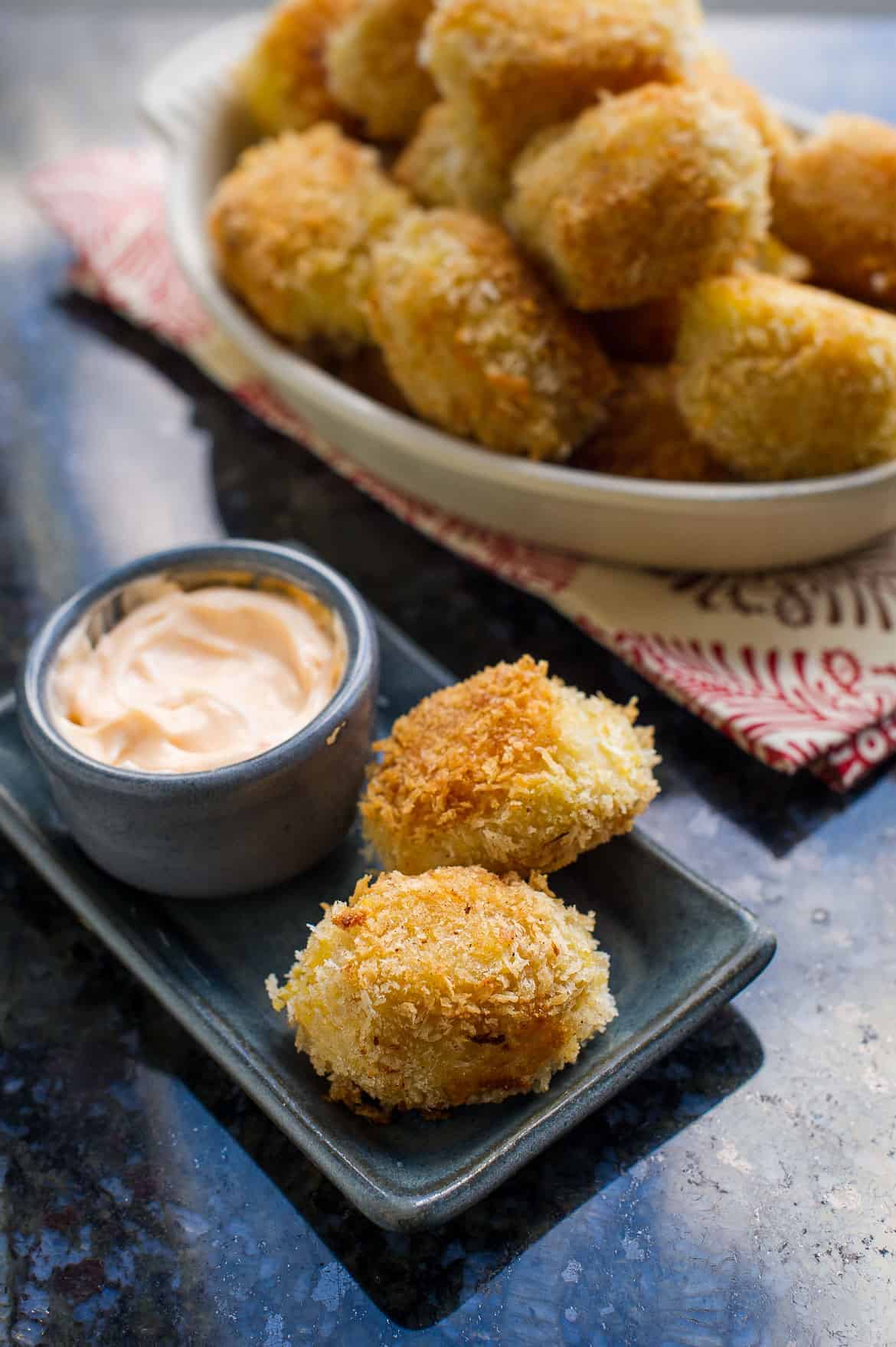 Potato Croquettes with Shrimp on a blue dish with a bowl of dipping sauce.