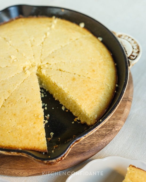 A round cast iron pan with slices of cornbread. 