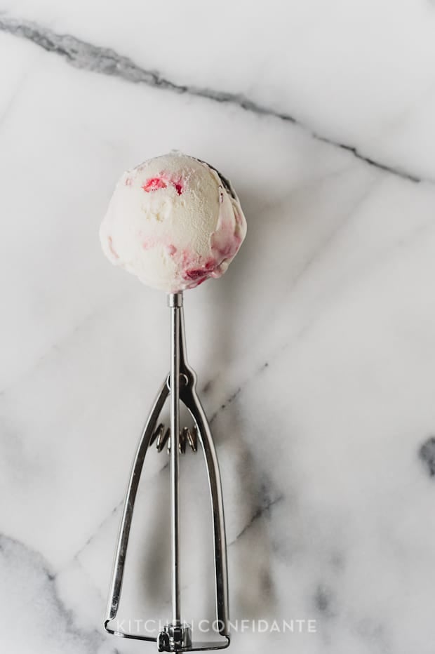 A scoop of homemade ice cream on a marble surface.