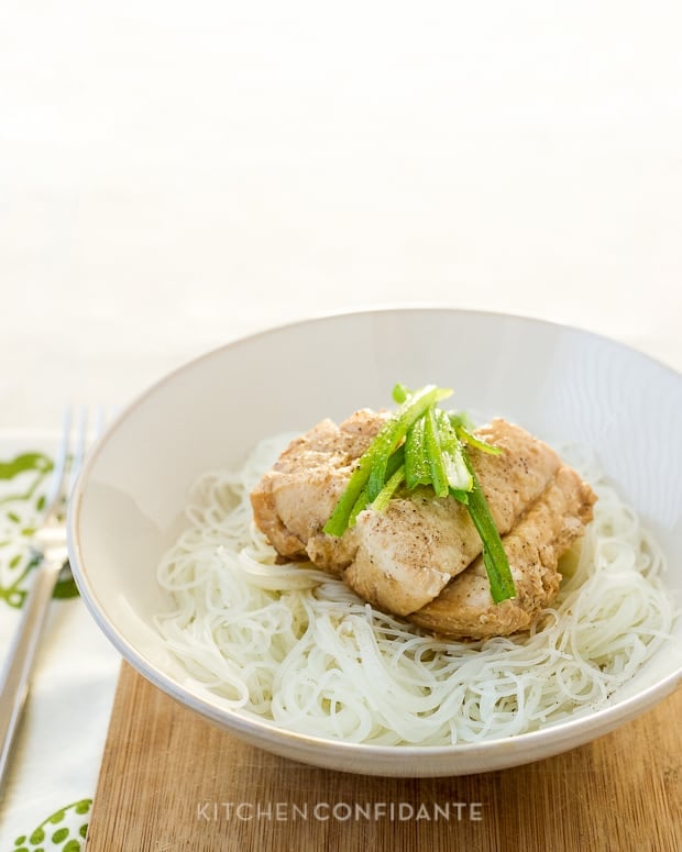 Steamed Cod with Ginger and Scallions served on rice noodles in a large bowl.