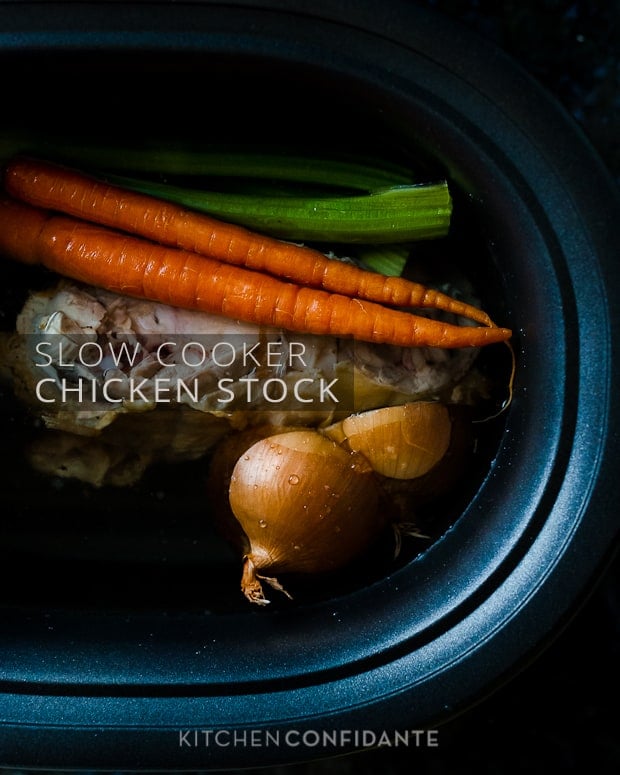 A slow cooker insert filled with a chicken carcass, carrots, celery, and onions, with the words, "Slow Cooker Chicken Stock".