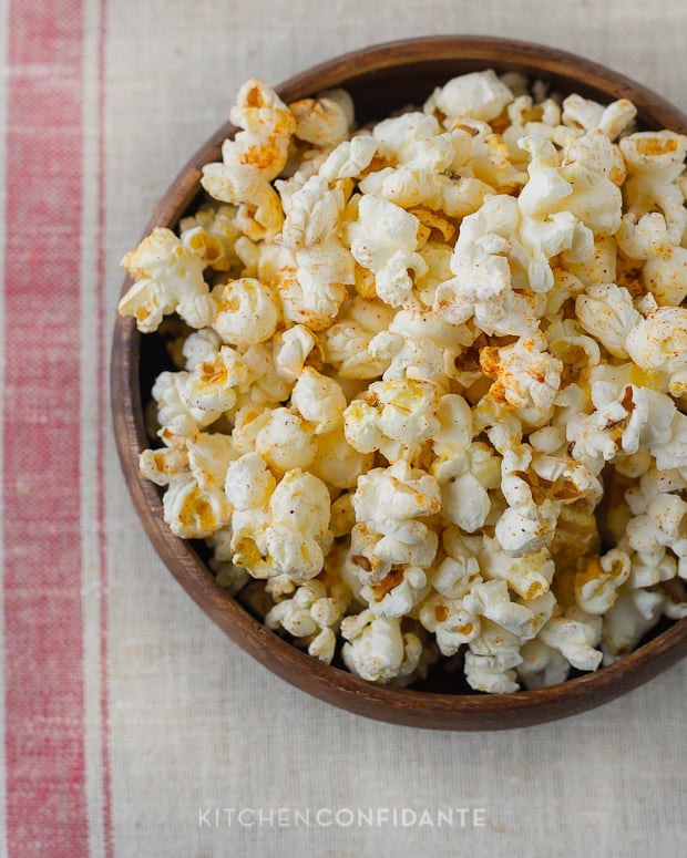 A wooden bowl of popcorn seasoned with brown sugar and cayenne pepper.