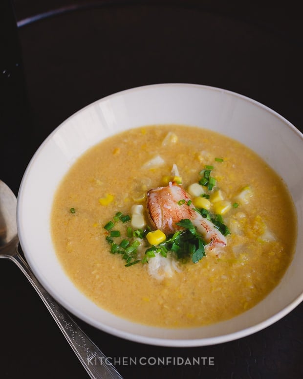 A bowl of Crab and Corn Chowder garnished with crab meat, corn, cilantro, and chopped chives.