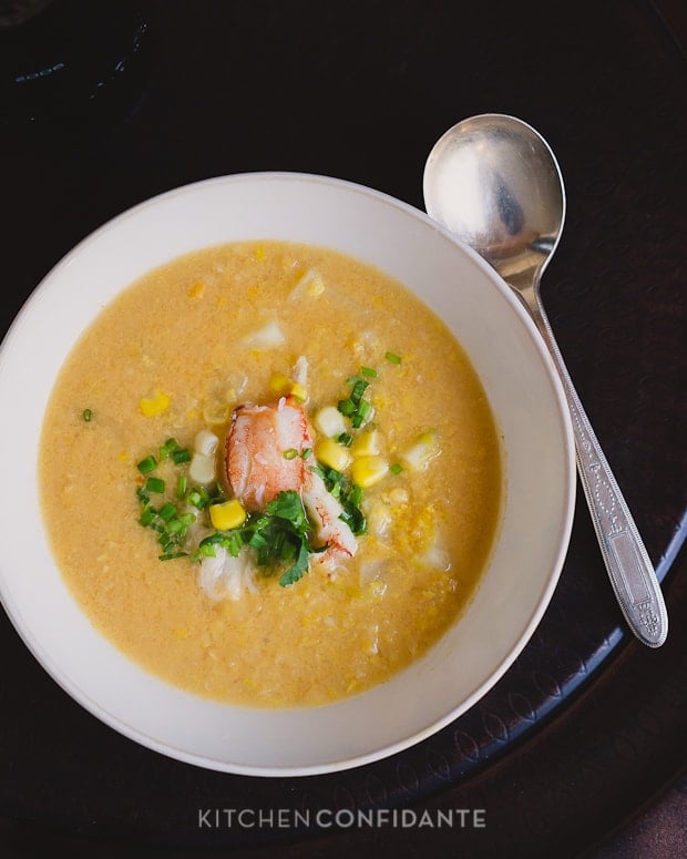 A bowl of Thai-style Crab and Corn Chowder topped with crab meat, corn, cilantro, and chopped chives.