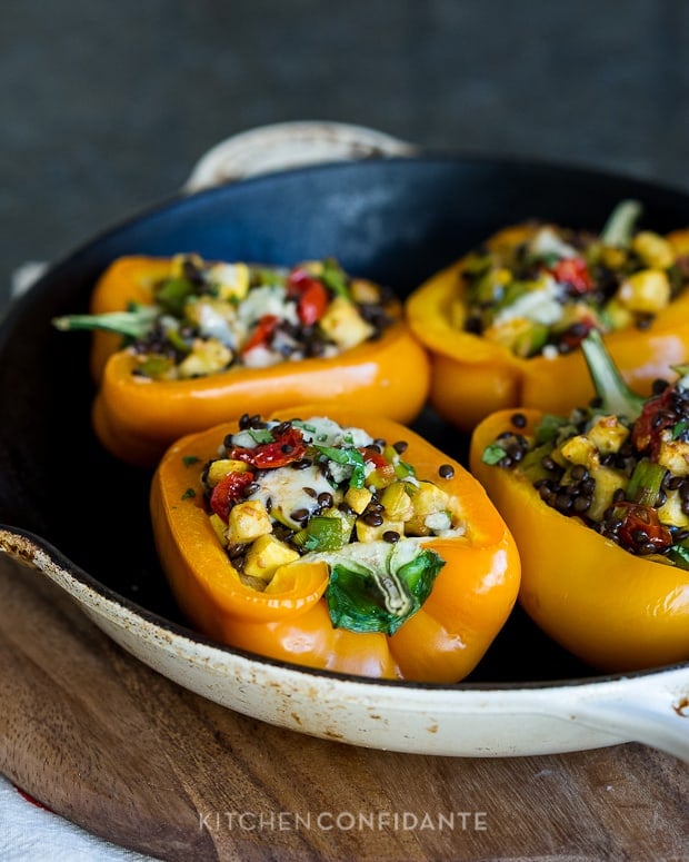 Lentil Stuffed Peppers made with halved orange bell peppers and stuffed with a mix of lentils, vegetables, and cheese.