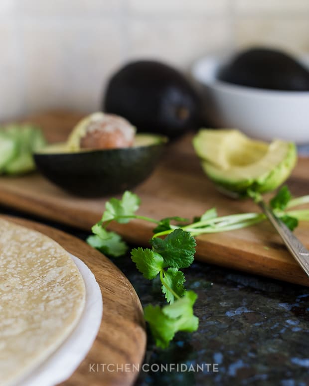 Pieces of fresh cilantro on a wooden cutting board.