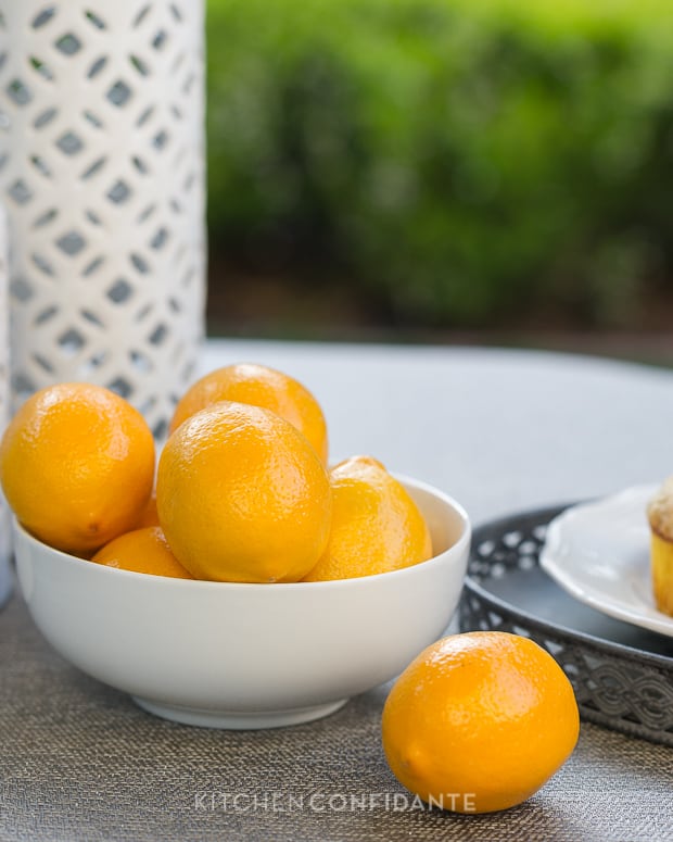 Bright fresh Meyer lemons in a white bowl.
