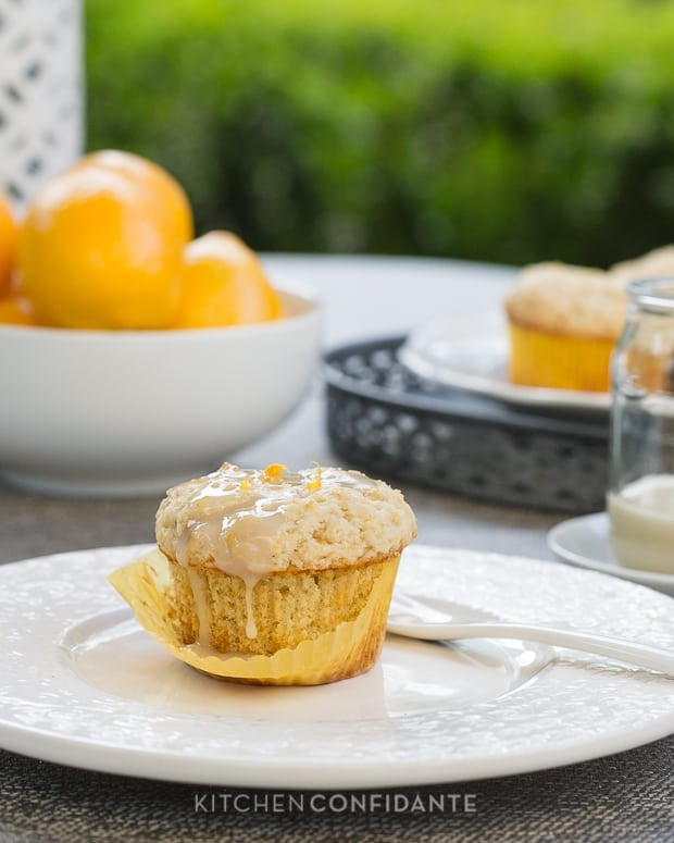 A glazed Meyer Lemon Ricotta Muffin served on a white plate.