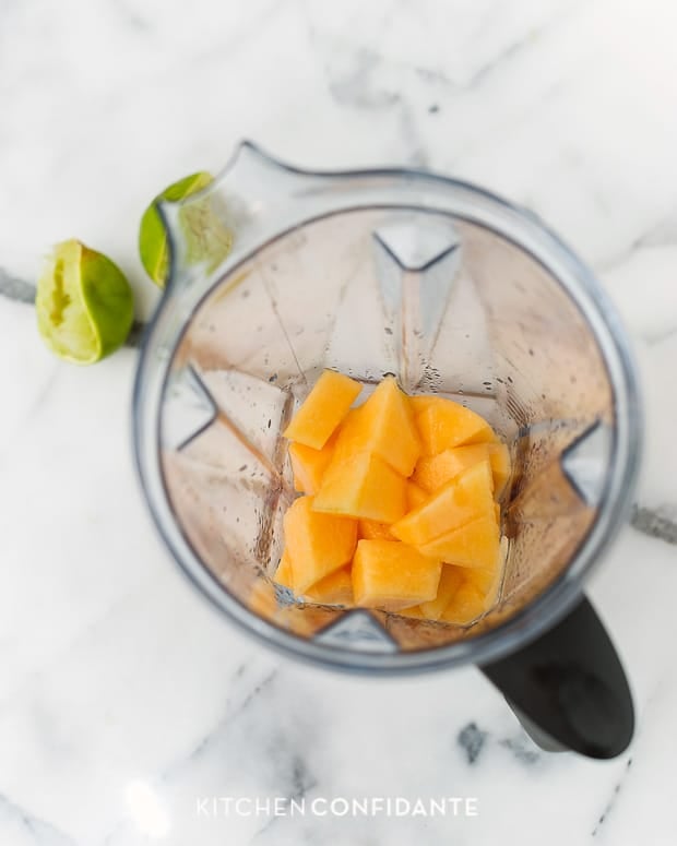 Lime juice and cubes of cantaloupe in a blender.