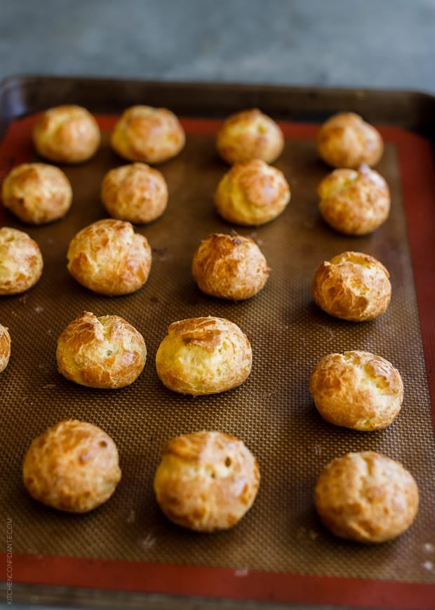 Homemade cheese puffs on a baking sheet.