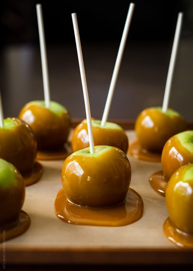 Homemade Caramel Apples made without corn syrup setting up on a lined tray.