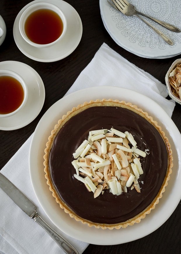 Coconut Custard Tart with Chocolate Ganache on a white serving plate.