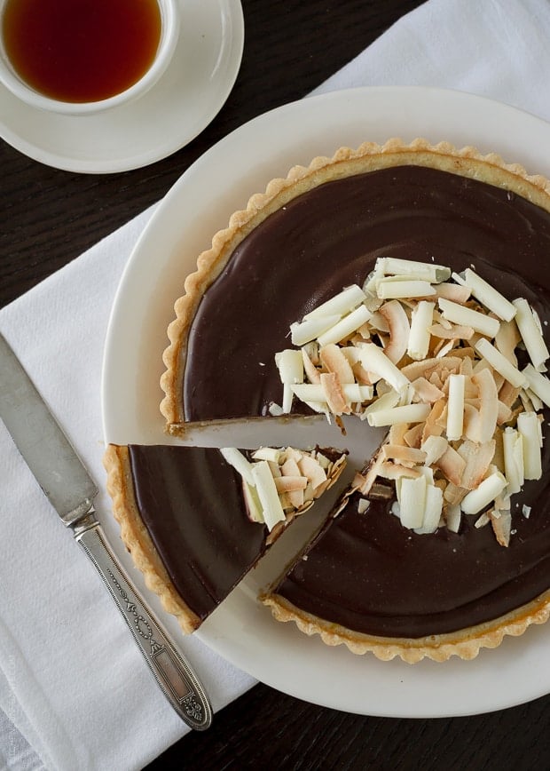 Removing a slice from a chocolate-topped tart.