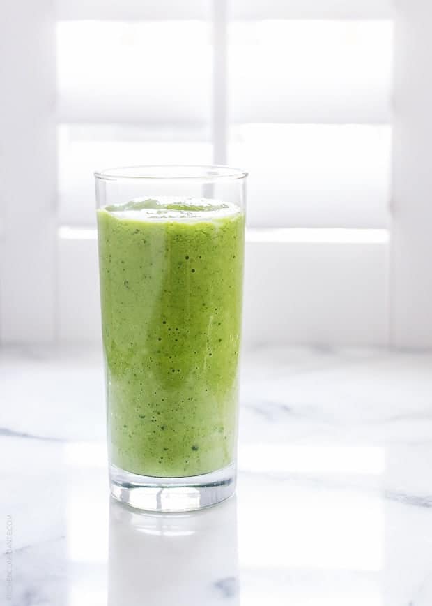 Mango Spinach Green Smoothie in a glass against a white background