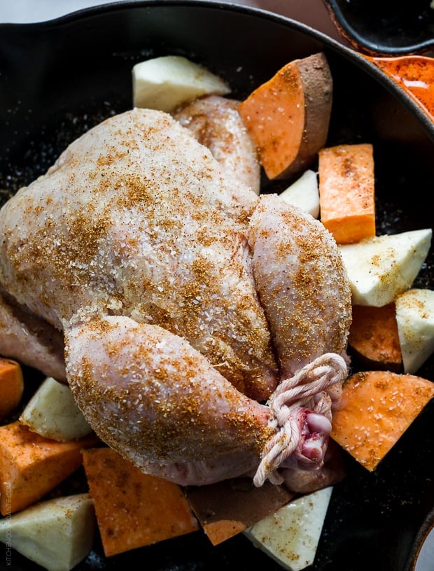 A trussed Cornish hen in a cast iron skillet.