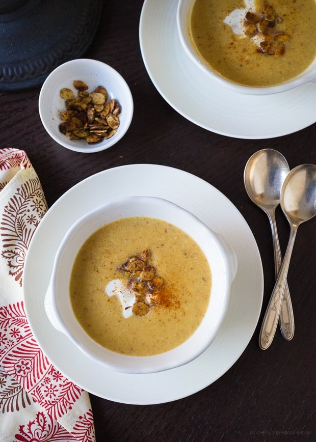 Bowls of Toasted Almond Butternut Squash Soup garnished with crème fraîche and toasted slivered almonds.