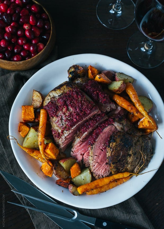 Cranberry Balsamic Crusted Chateaubriand surrounded by roasted carrots and potatoes.
