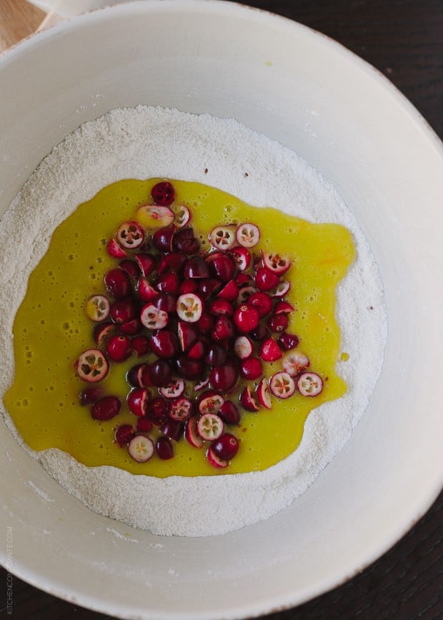 Dry ingredients, wet ingredients, and chopped cranberries in a bowl. 