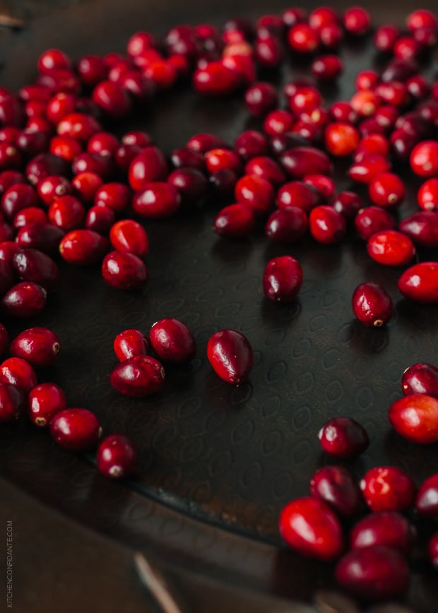 Cranberries on a dark surface.