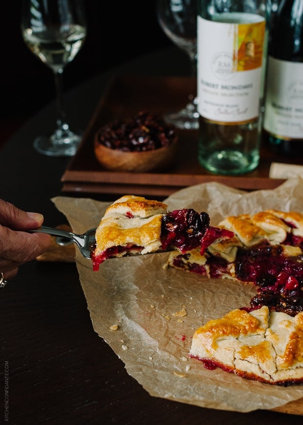Removing a slice from a rustic cranberry galette.