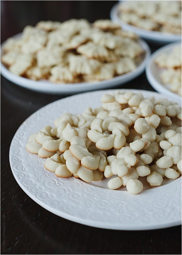 White serving plates filled with Lemon Spritz Cookies.