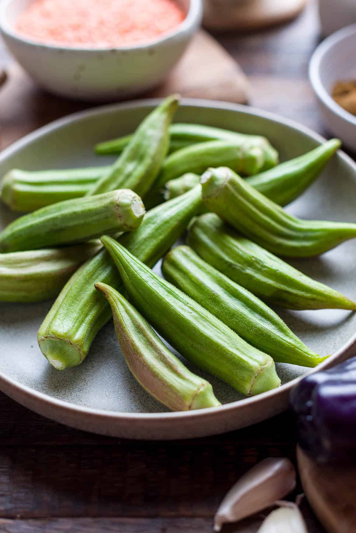 Fresh green okra on a wooden surface.