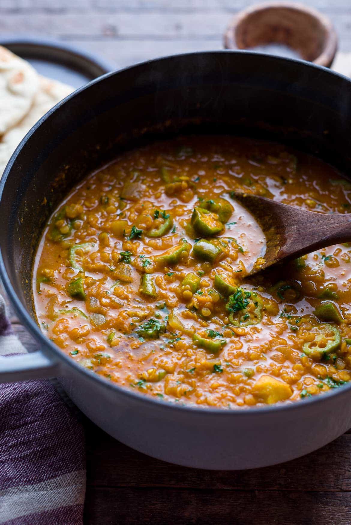 A large pot filled with Lentil Okra Curry and garnished with fresh cilantro.