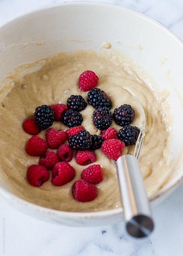 Coffee cake batter and berries in a white bowl.