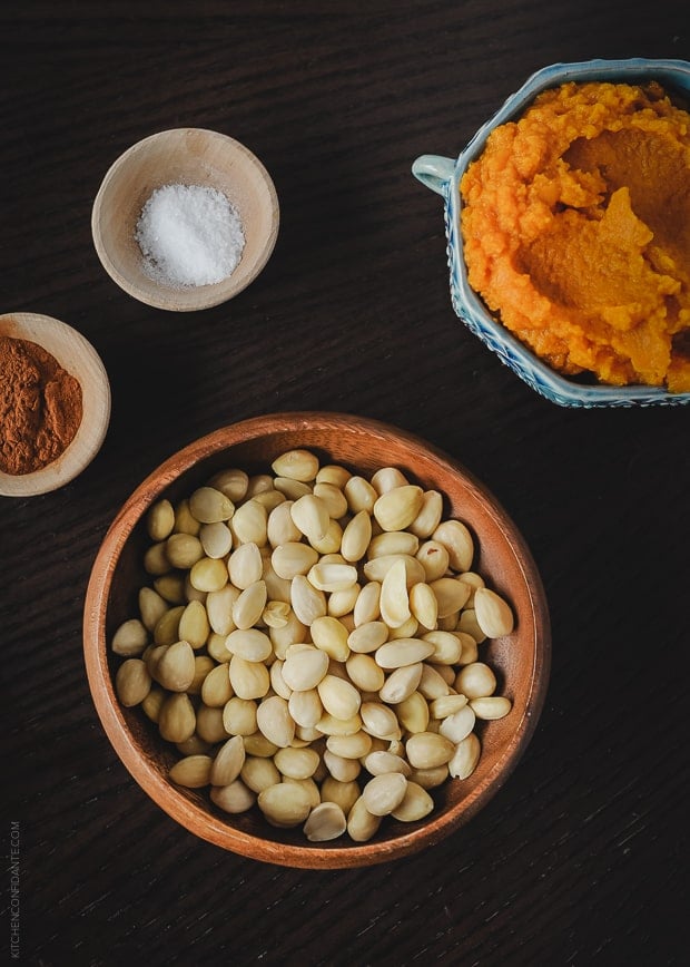 Canned pumpkin, cinnamon, salt, and marcona almonds arranged in bowls.