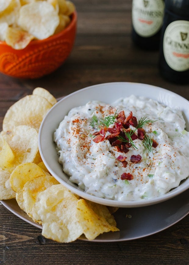 A bowl of Bacon Leek Dip served alongside potato chips.