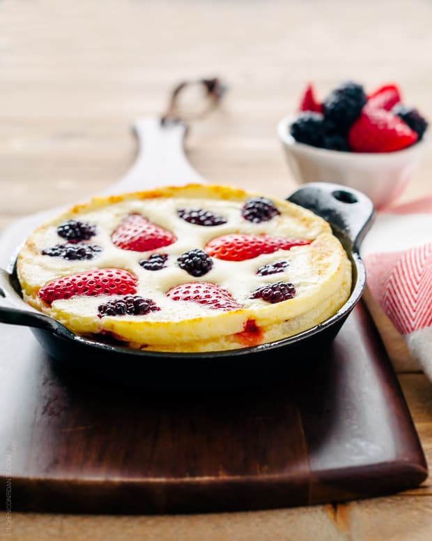 A puffed Mixed Berry Dutch Baby Pancake in a cast iron pan straight from the oven.