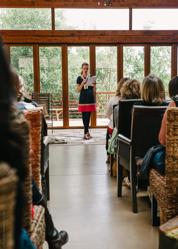 A speaker reading from notes at the Big Traveling Potluck 2014.