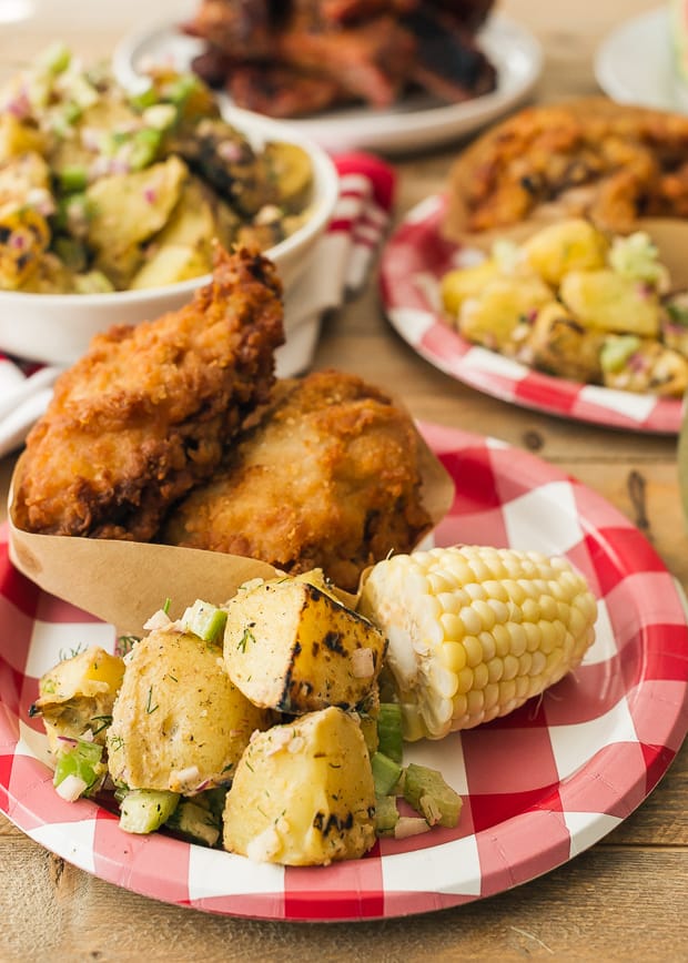 Grilled Potato Salad, corn on the cob, and fried chicken on a plate.