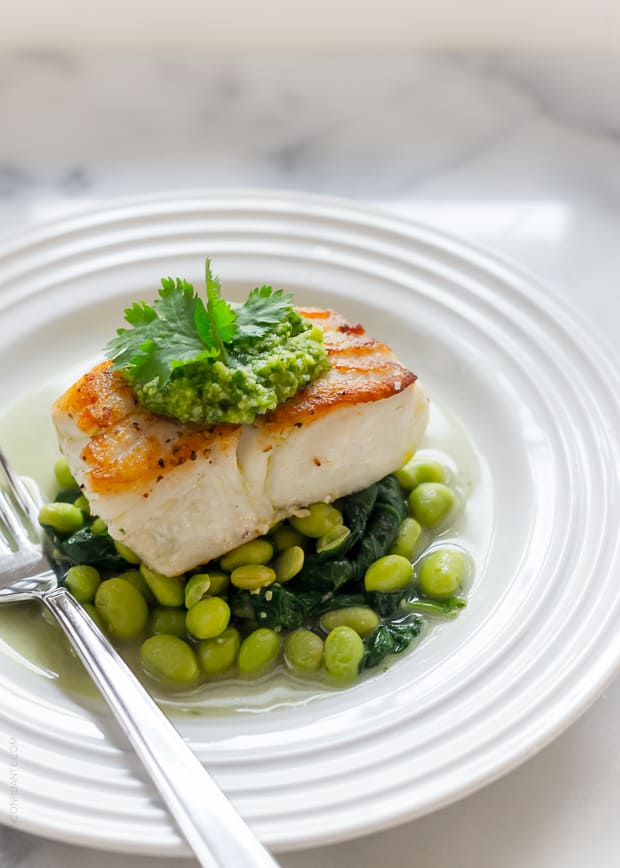 A piece of pan-roasted fish on a bed of edamame.