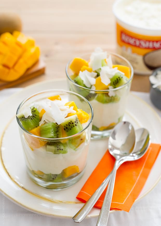 Tropical Rice Pudding layered in glasses with coconut flakes, chopped kiwi and chopped mango.