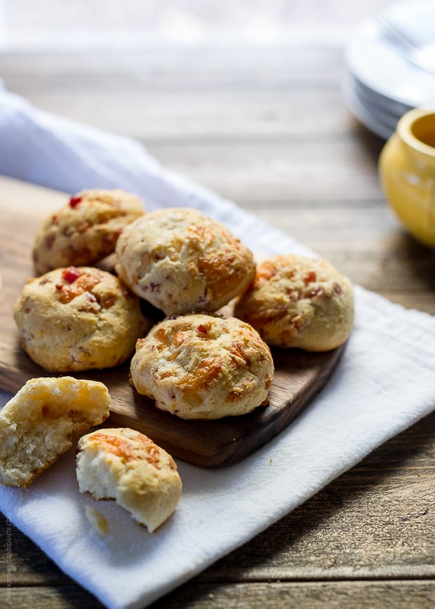 Cheesy Pancetta Biscuits on a wooden surface with a napkin beneath.