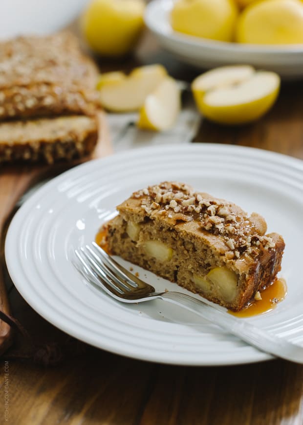 A slice of Apple Pecan Loaf cake on a white plate with a fork.