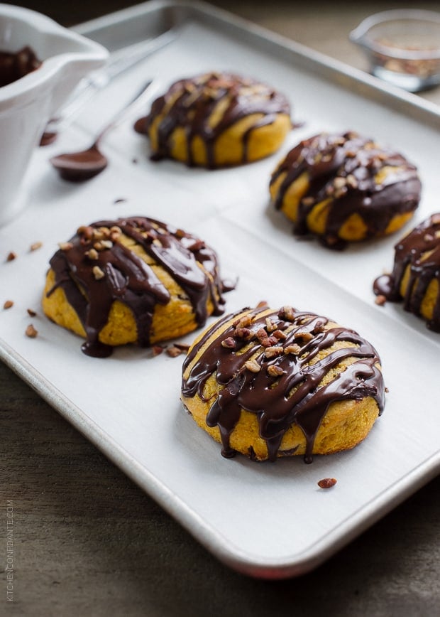 Pumpkin Cornmeal Scones drizzled with chocolate and topped with pecans.
