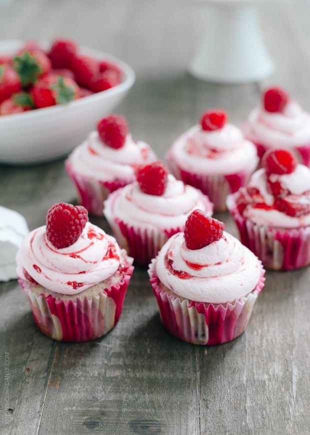 Roasted Berry Cupcakes topped with pink buttercream and a single raspberry. 